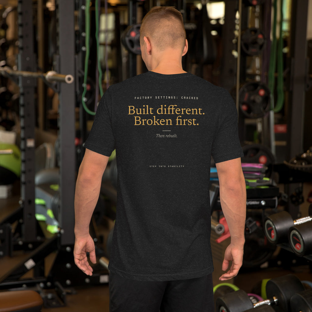 Built Different T-shirt, Black Heather, back: Built different. Broken first. Then rebuilt.