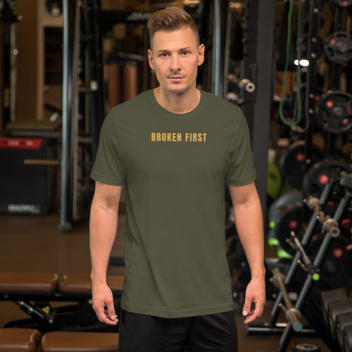 Built Different T-shirt worn by a man in a gym, Military Green, gold BROKEN FIRST across the chest